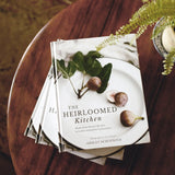Stack of cookbooks on a wooden table with a natural background