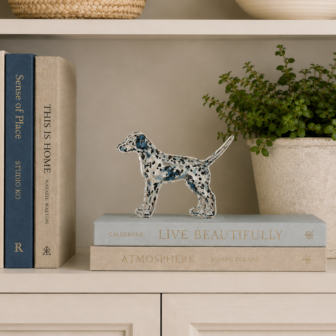 Decorative shelf with books, a small dog statue, and a potted plant.