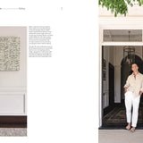 Man standing in a doorway of a stylish home with decor elements.
