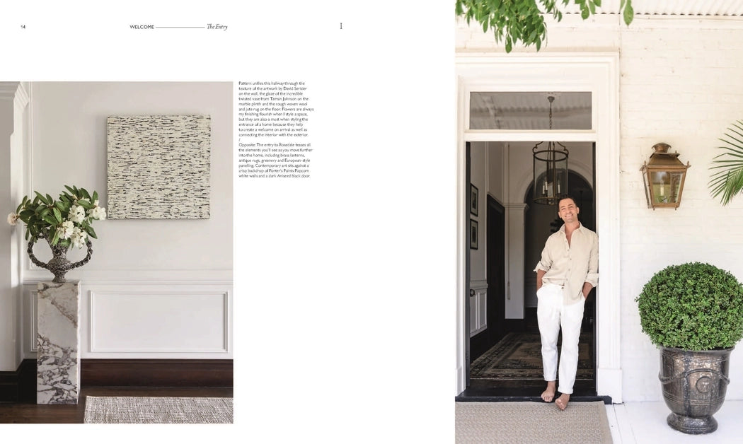 Man standing in a doorway of a stylish home with decor elements.