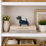 Decorative shelf with books, a figurine, and plants
