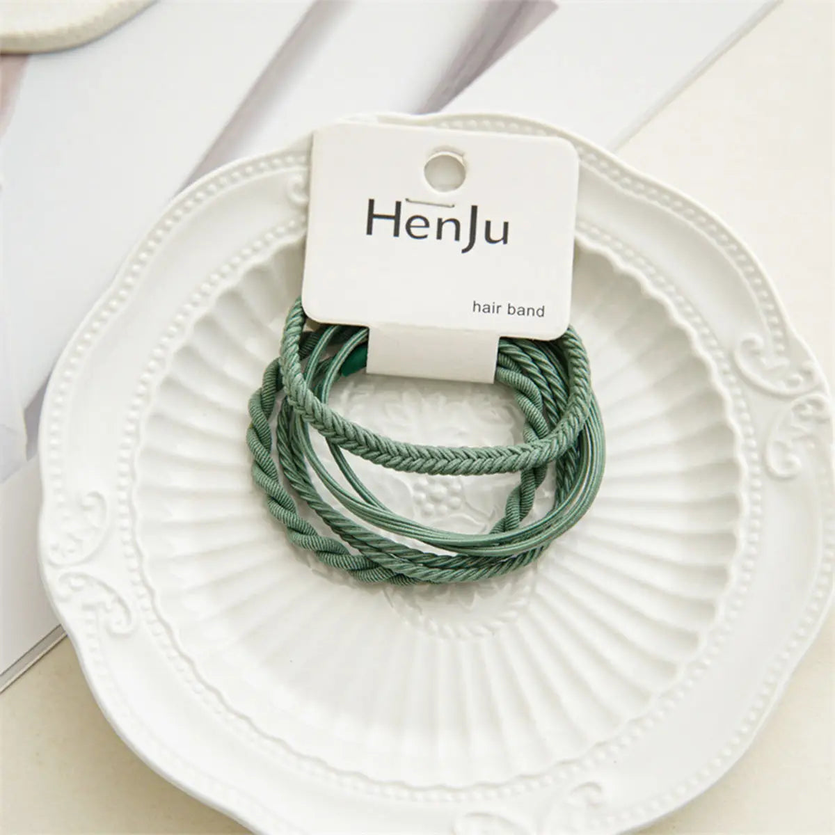Green hair bands on a white plate with HenJu label