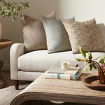 Living room with a beige sofa, decorative pillows, and a wooden coffee table.