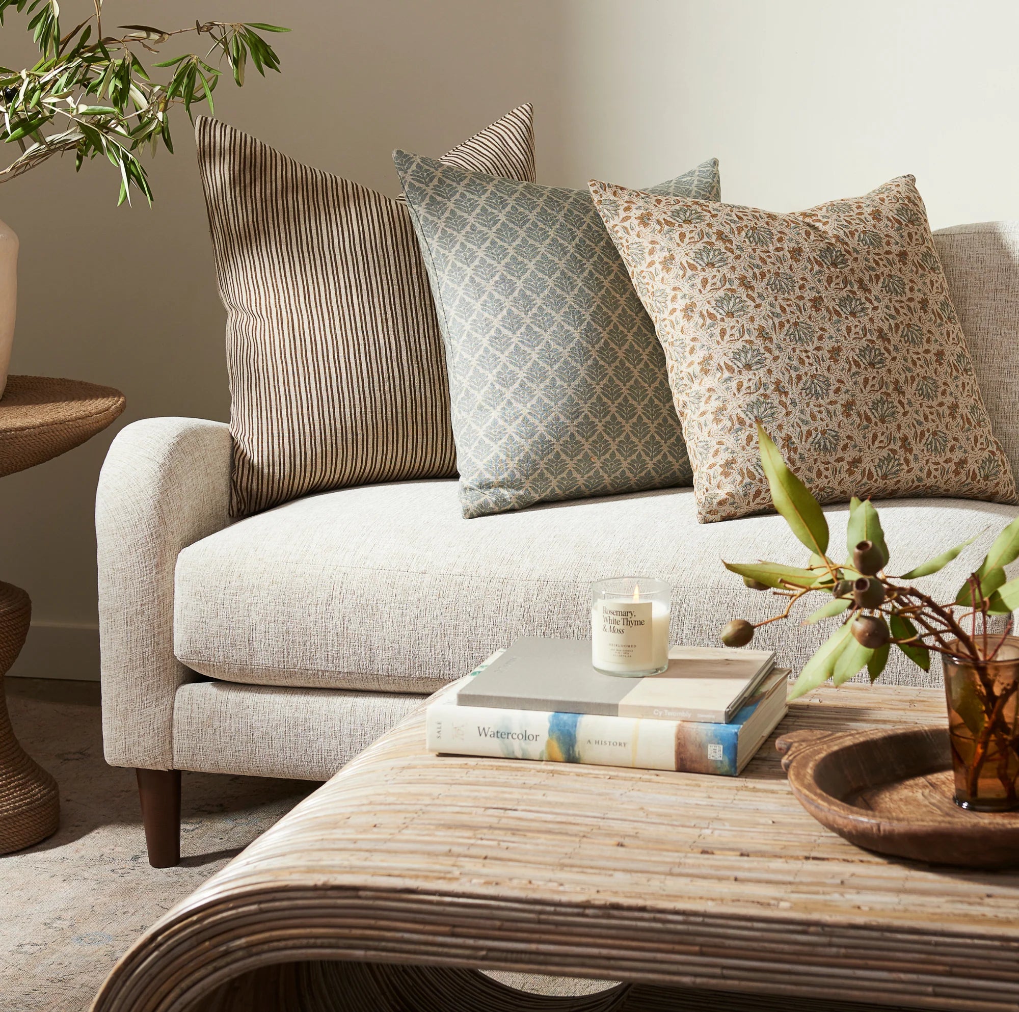 Living room with a beige sofa, decorative pillows, and a wooden coffee table.