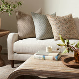 Living room with a beige sofa, decorative pillows, and a wooden coffee table.