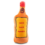 back of Plush orange “Furball Cinnamutt Whisky” dog toy shaped like a whiskey bottle with embroidered label and built-in squeaker saying 'lick it. love it. squeak it'