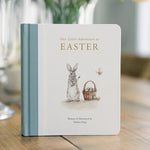 Book titled 'Our Little Adventures at Easter' with a rabbit illustration on a wooden table.