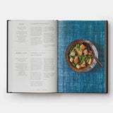 Open cookbook showing a recipe for simmered pork belly with green beans on a blue textured background.