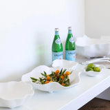 Two green bottles on a white surface with decorative elements