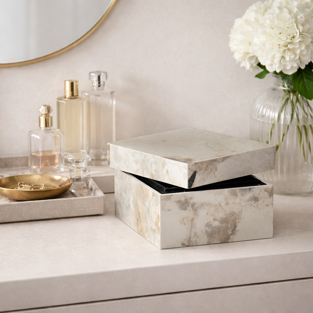 Marble-patterned box on a vanity with decorative items including a vase of white flowers.