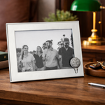Framed black and white photo of a family on a wooden table with golf books and accessories.