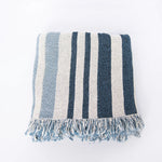 Striped blue and white blanket with fringes on a white background