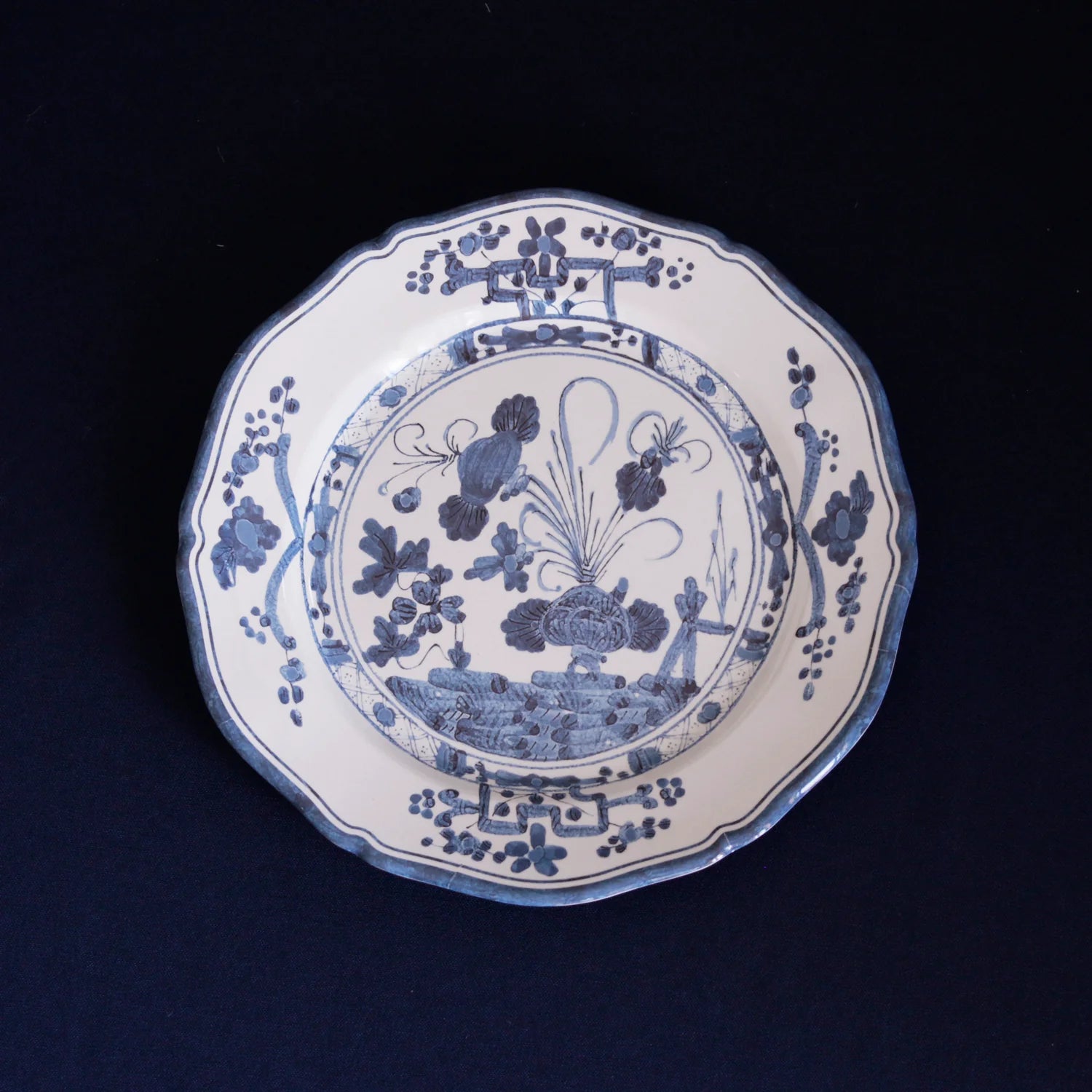 beatriz ball vida faenza 11" dinner plate with floral and landscape design on a black background