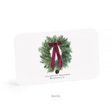 Note card with a Christmas wreath and red ribbon on a white background