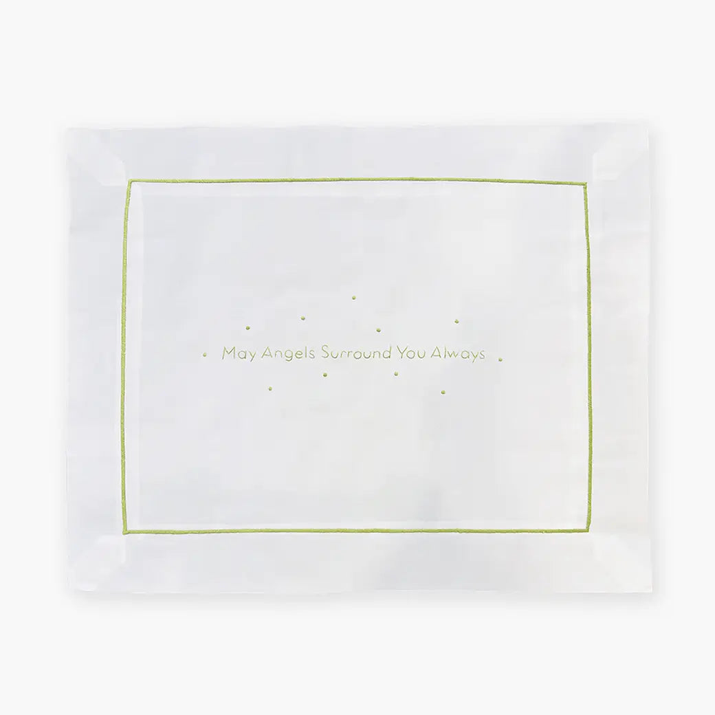 White pillowcase with embroidered green text 'May Angels Surround You Always' on a white background