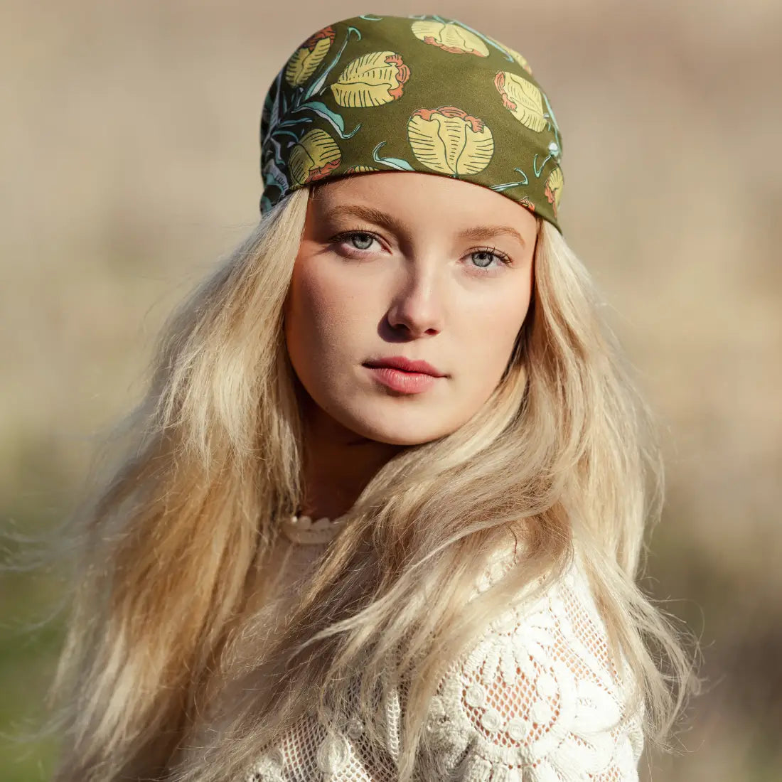 Woman wearing a patterned headband with a blurred natural background