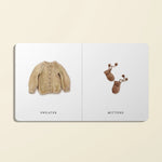 Illustration of a sweater and mittens on a book page with labels.