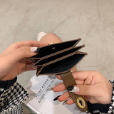 Person holding a brown leather wallet with a neutral background