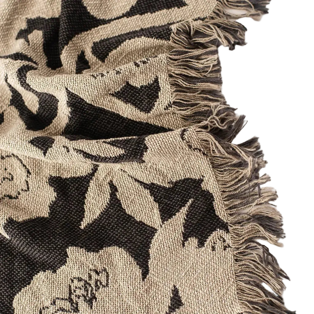 Close-up of a patterned fabric with black and beige design on a white background