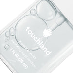 Clear hand sanitizer bottle with 'touchland' branding on a white background