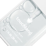 Clear hand sanitizer bottle with 'touchland' branding on a white background