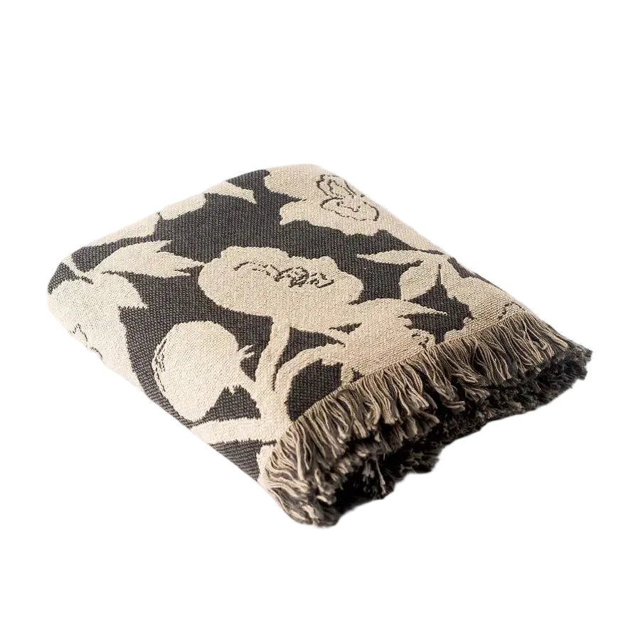 Floral patterned throw blanket with fringe on a white background