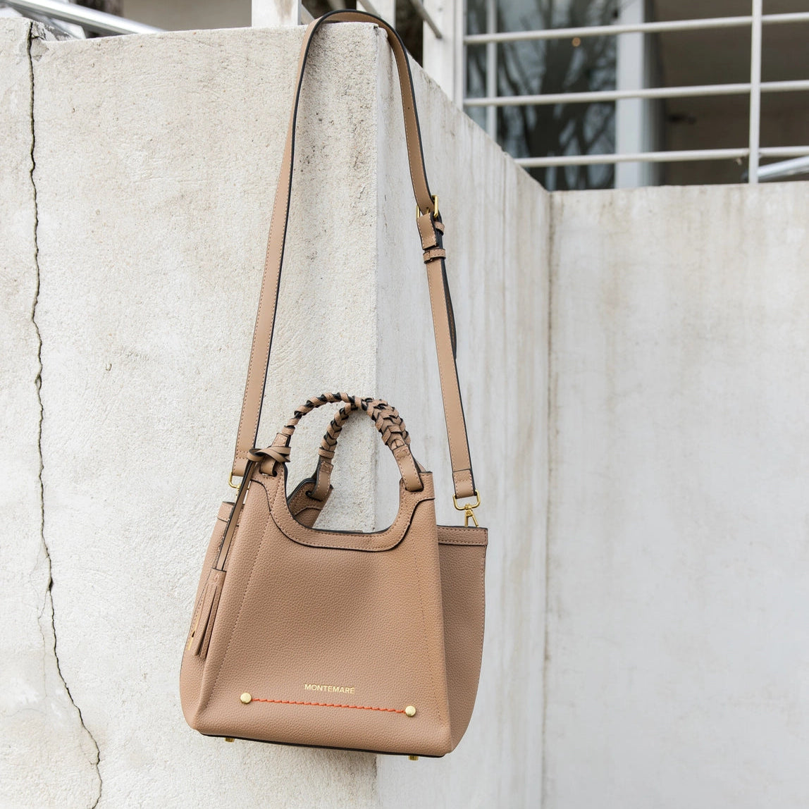 Montemare Sedona Crossbody in Latte  with a strap on a textured wall