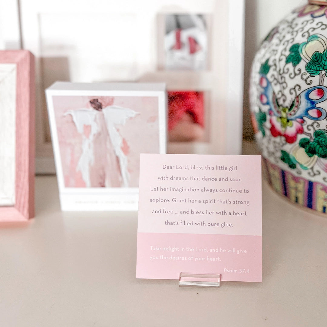 Pink card with text on a stand, framed pictures in the background