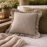 Striped pillow with ruffled edges on a couch outdoors