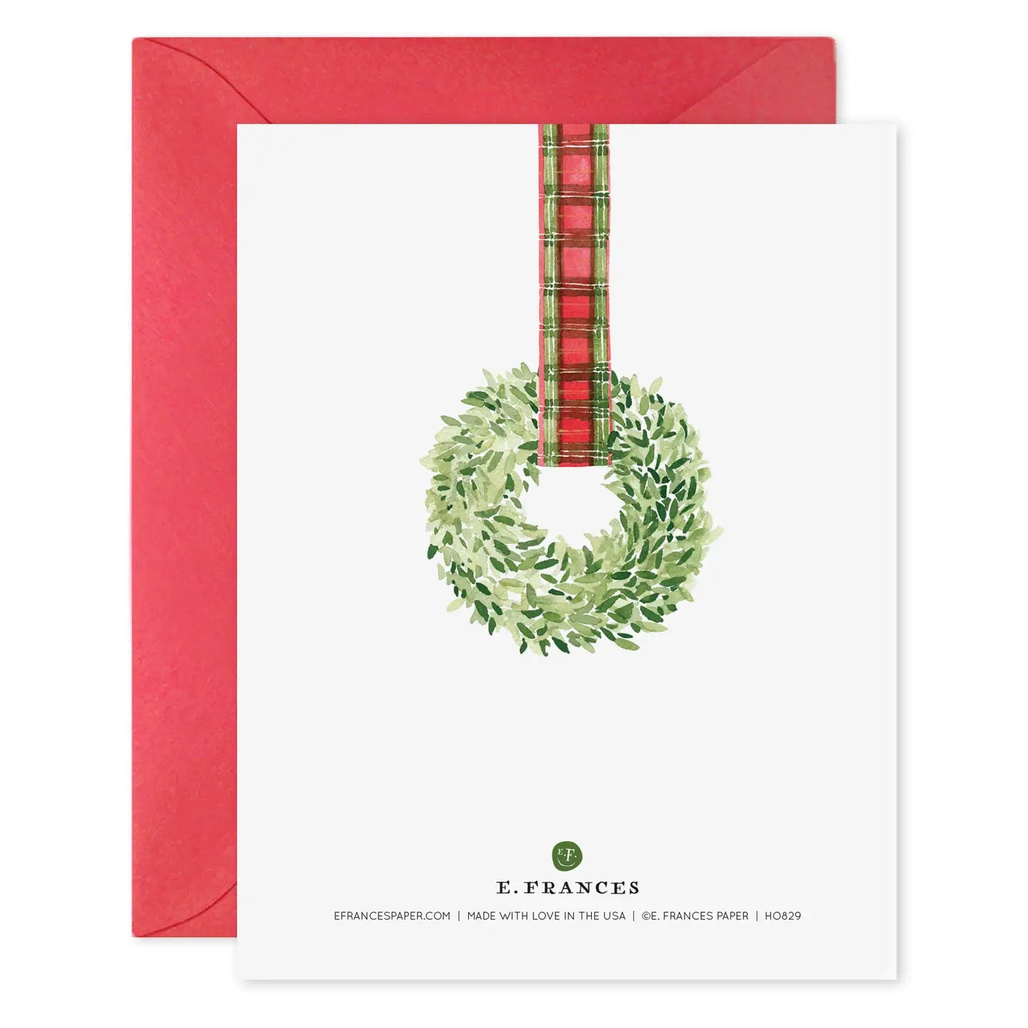 Greeting card with a green wreath and plaid ribbon on a white background with a red envelope.