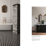Bathroom interior with a freestanding bathtub, decorative wall art, and black vanity.