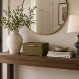 Wooden console table with decorative items including a vase, box, books, and lamp.