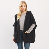 Woman wearing a black hooded coat on a light gray background