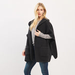 Woman wearing a black hooded coat on a white background