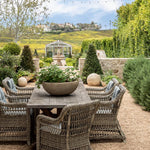Outdoor patio set with table and chairs in a garden setting