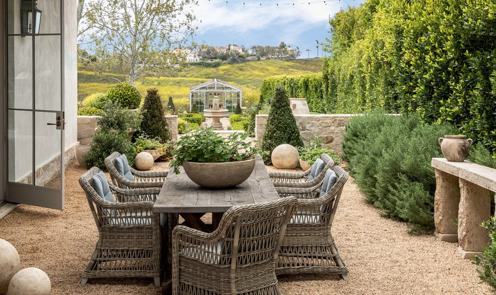 Outdoor patio set with table and chairs in a garden setting