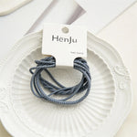 Three gray hair bands on a white plate with a HenJu label.