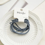 Three gray hair bands on a white plate with a HenJu label.