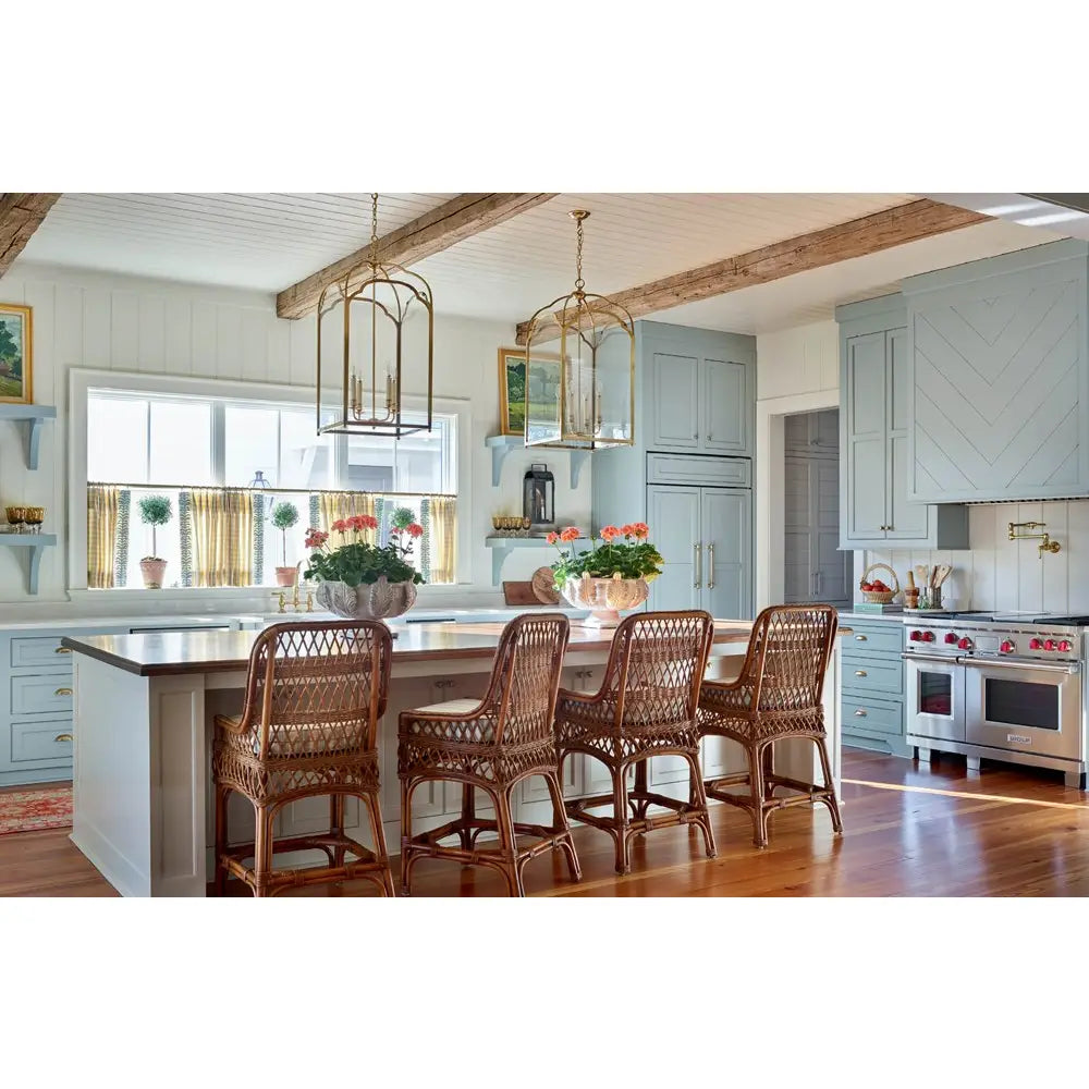 Modern kitchen with wooden island and chairs, light blue cabinets, and decorative elements.