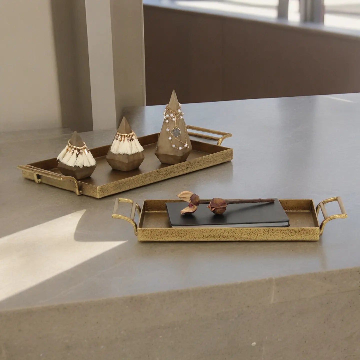 Decorative trays with small sculptures on a stone surface