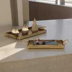 Decorative trays with small sculptures on a stone surface