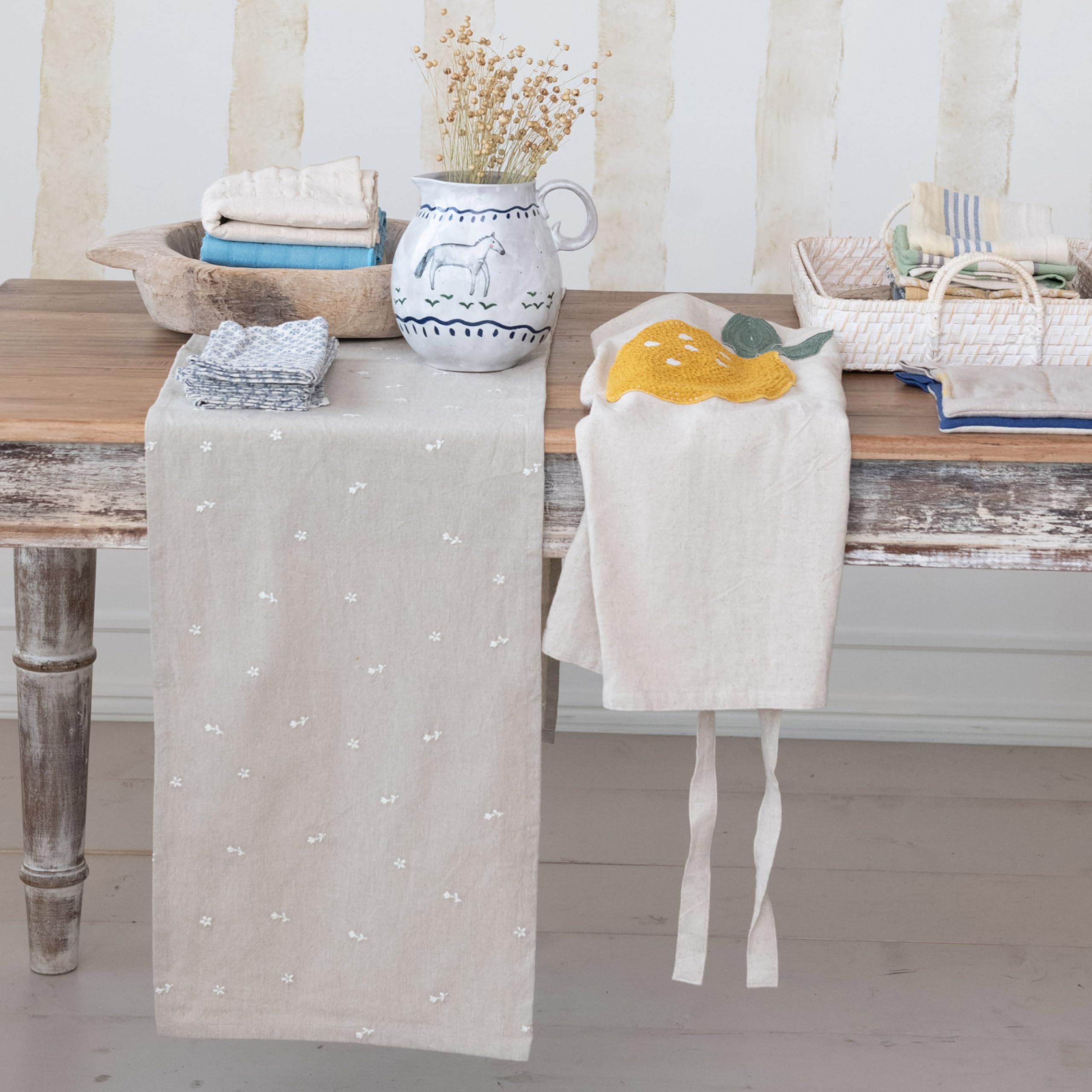 Decorative table setting with a star-patterned runner and a lemon-themed towel on a wooden table.