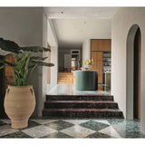 Interior of a home with a large vase and plant on a checkered floor