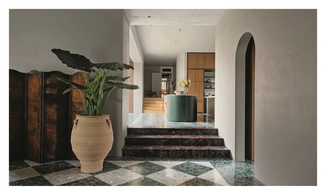 Interior of a home with a large vase and plant on a checkered floor