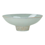 glazed ceramic wide flared  pedestal bowl with ribbed textured base on white background