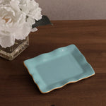 encanto vento small rectangular tray turquoise on white background on a wooden surface with white flowers in the background