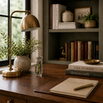 Home office desk with books, a lamp, and decorative items.