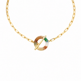 A gold chain necklace featuring a circular toggle clasp with a marbled beige and brown resin center and a small green accent.
