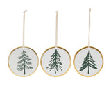 Three circular Christmas ornaments with green tree designs on a white background