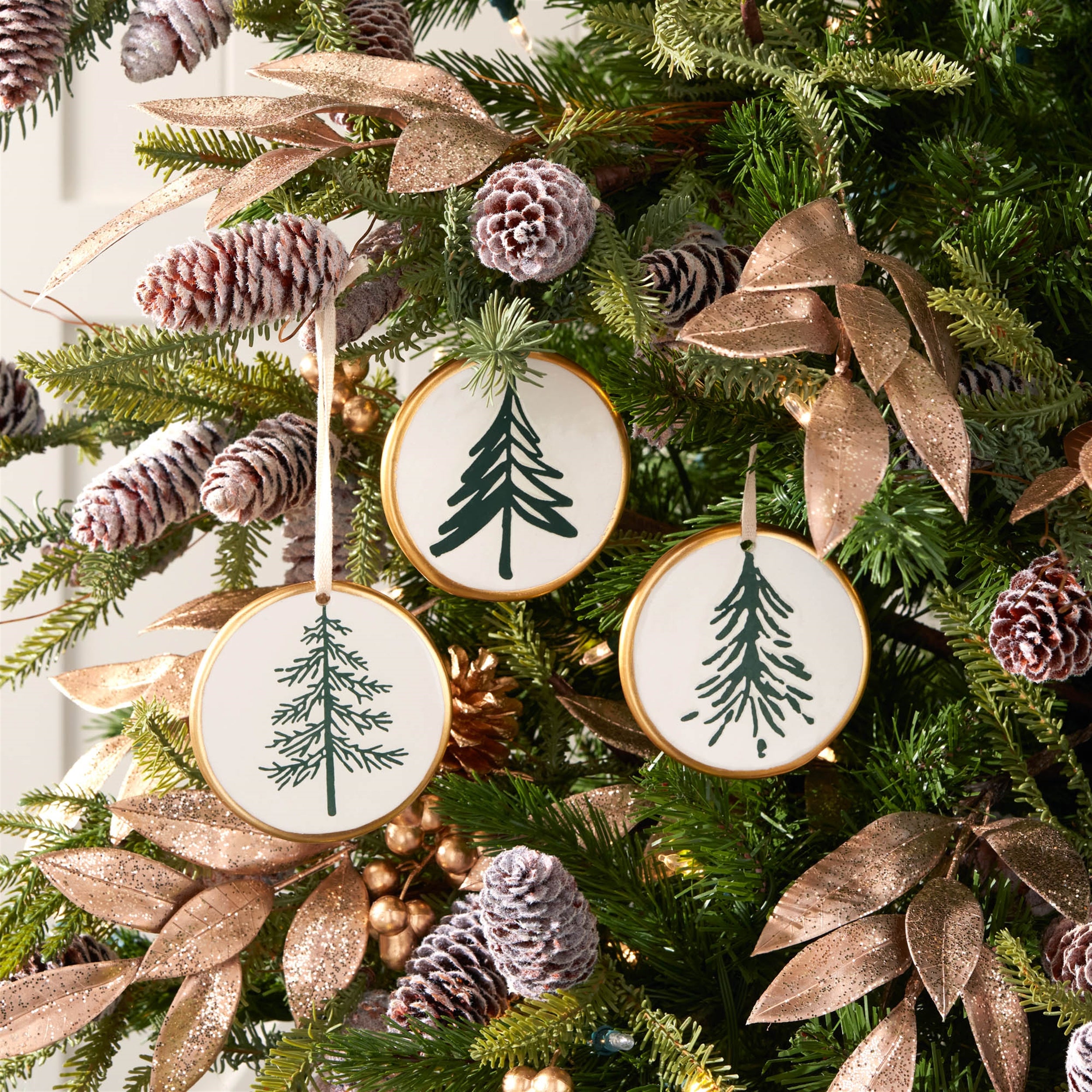 Decorative Christmas tree with pine cone ornaments and green tree designs.